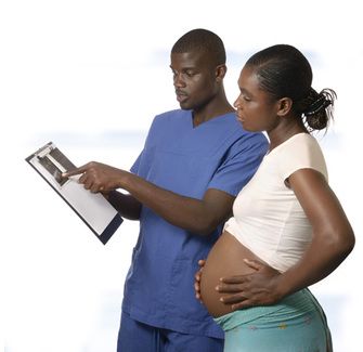 A pregnant woman and a doctor look at a chart